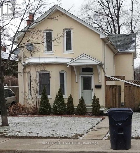 A house with a trash can in front of it.