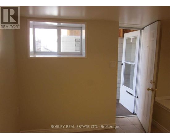A room with a window and a door leading to a bathroom.