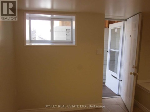 A room with a window and a door leading to a bathroom.
