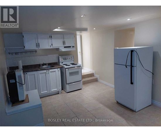 A kitchen with a refrigerator, stove, and cabinets.