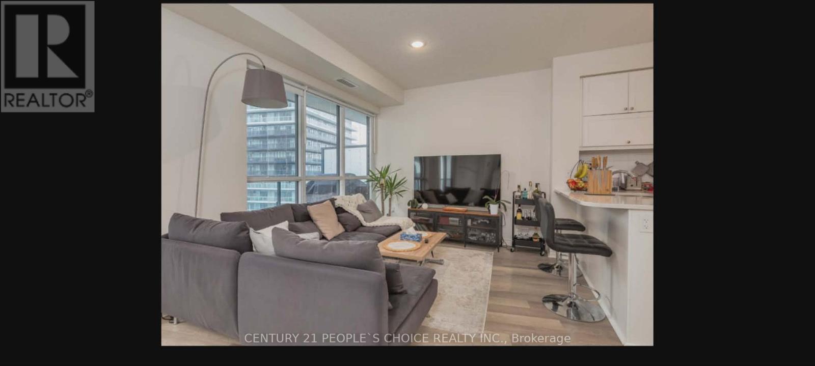 A living room with a grey couch and a television.
