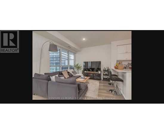 A living room with a grey couch and a television.