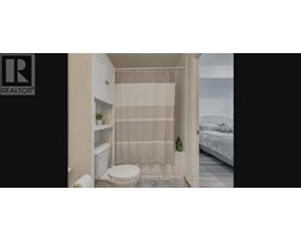 A small bathroom with a toilet, a shower curtain, and a bed in the background.