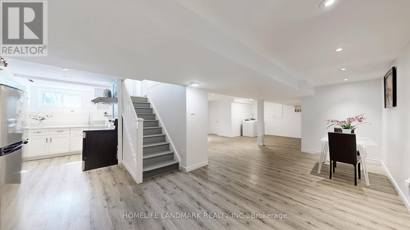 A spacious living room with a staircase leading to the upper floor.