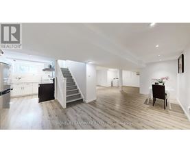 A spacious living room with a staircase leading to the upper floor.