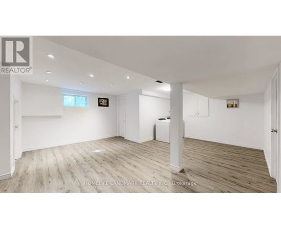 A spacious room with wooden flooring and white walls, featuring a large window and a white radiator.