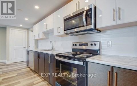 A modern kitchen with white cabinets and a stainless steel oven.
