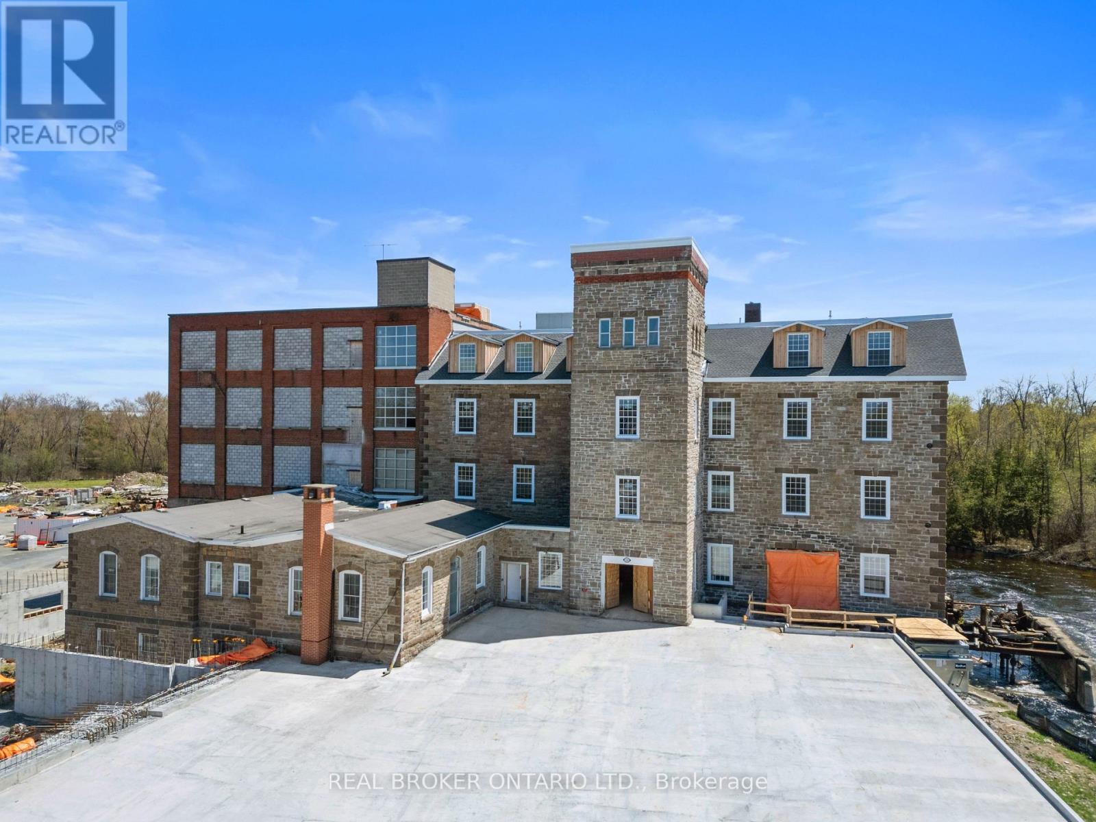 A large building with a parking lot in front is being advertised by REALTOR®.