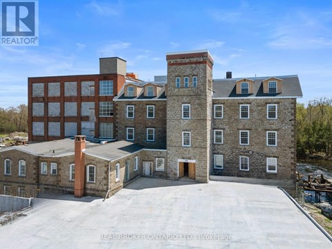 A large building with a parking lot in front is being advertised by REALTOR®.