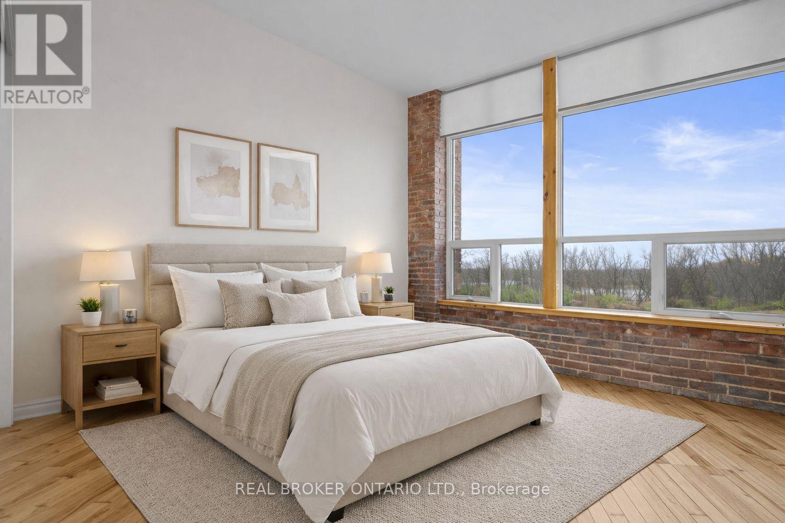 A bedroom with a large bed and a window overlooking a wooded area.