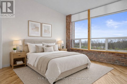 A bedroom with a large bed and a window overlooking a wooded area.