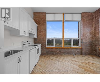 A kitchen with white cabinets and a wooden floor.