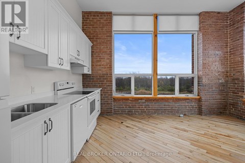 A kitchen with white cabinets and a wooden floor.