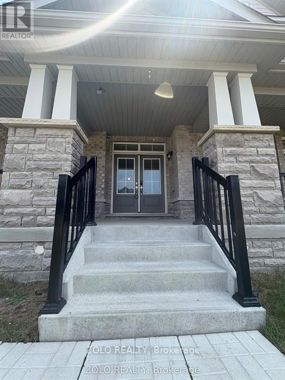 A house entrance with a stone pillar and black railings.