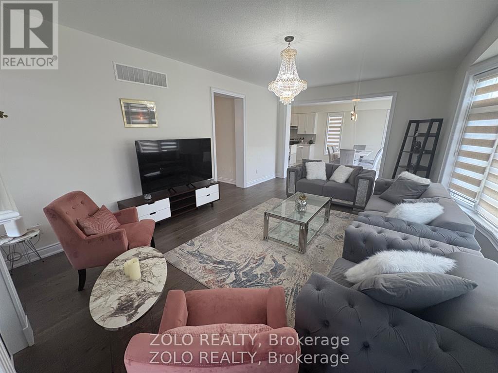 A living room with a red chair and a grey couch.