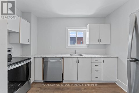 A kitchen with white cabinets and a window above the sink.