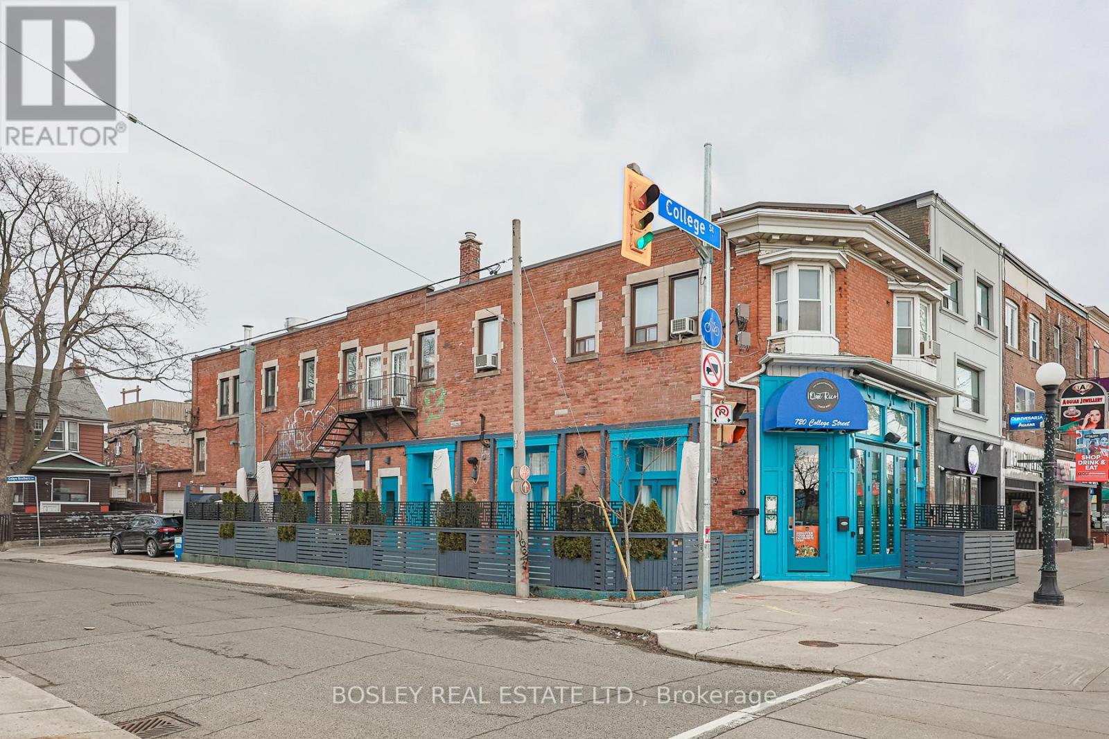 A street view of a building with a blue awning and a traffic light.