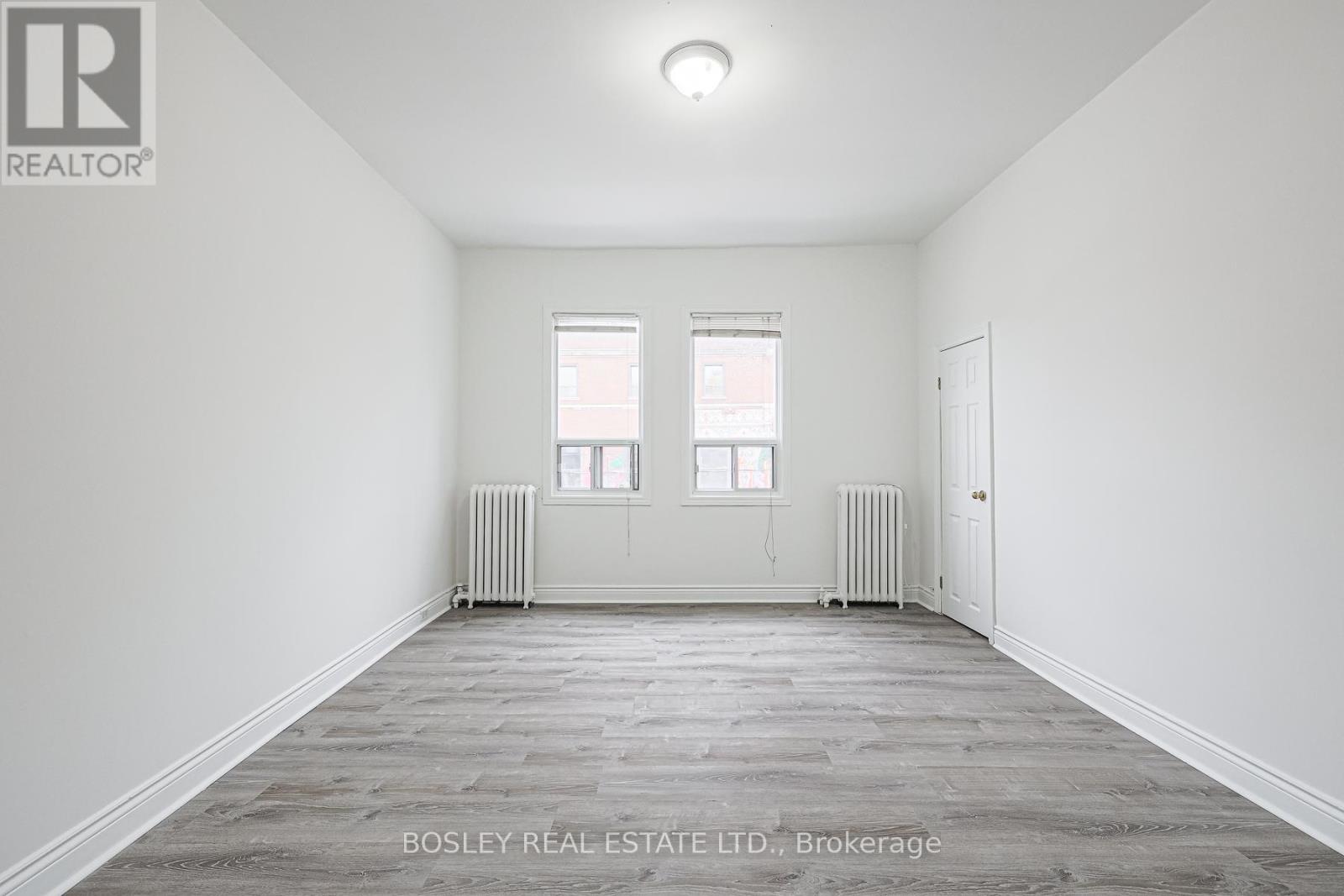 A spacious room with a grey floor and white walls.
