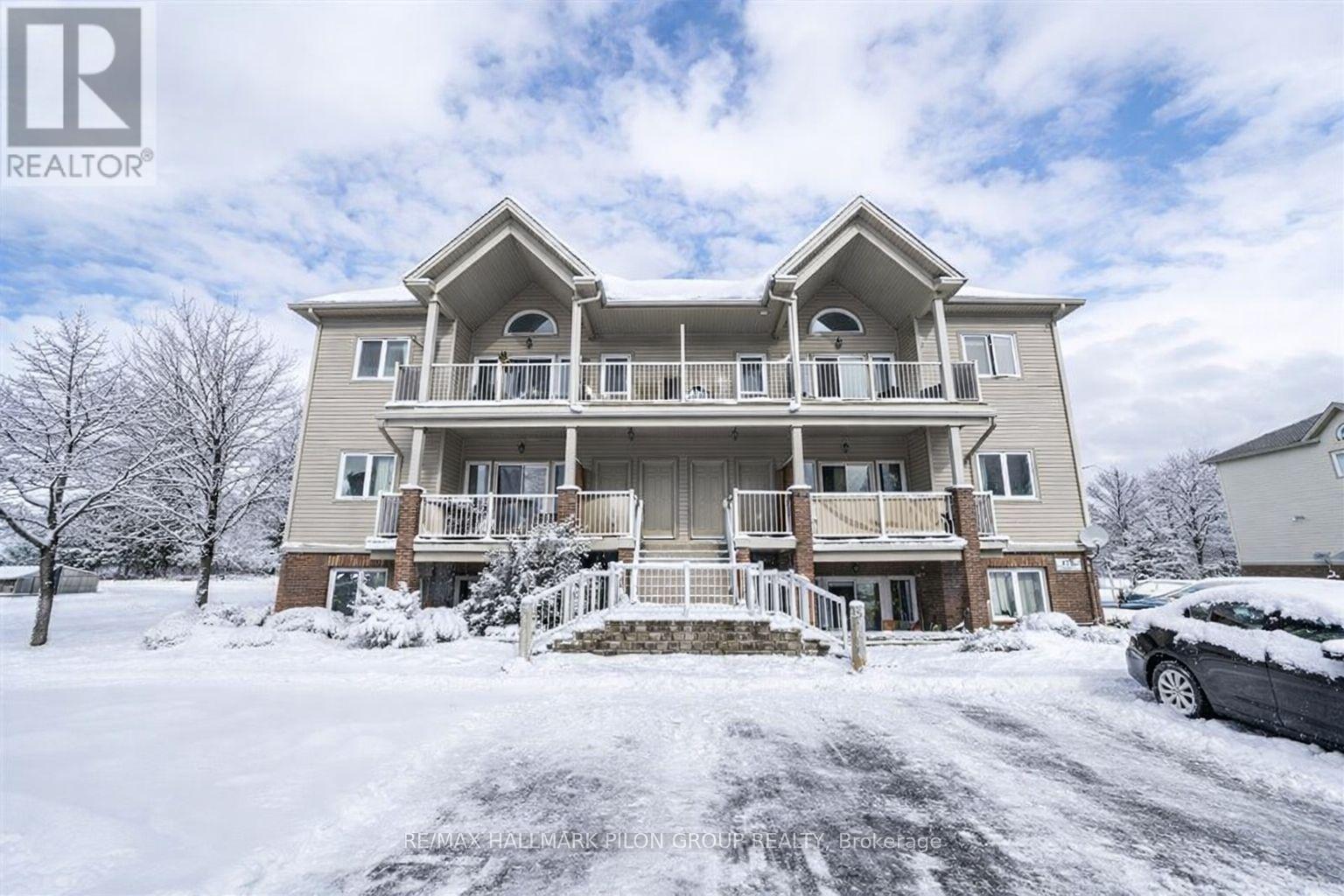 A large, two-story house with a balcony and a car parked in front.