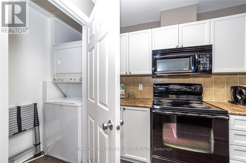 A kitchen with white cabinets and black appliances.