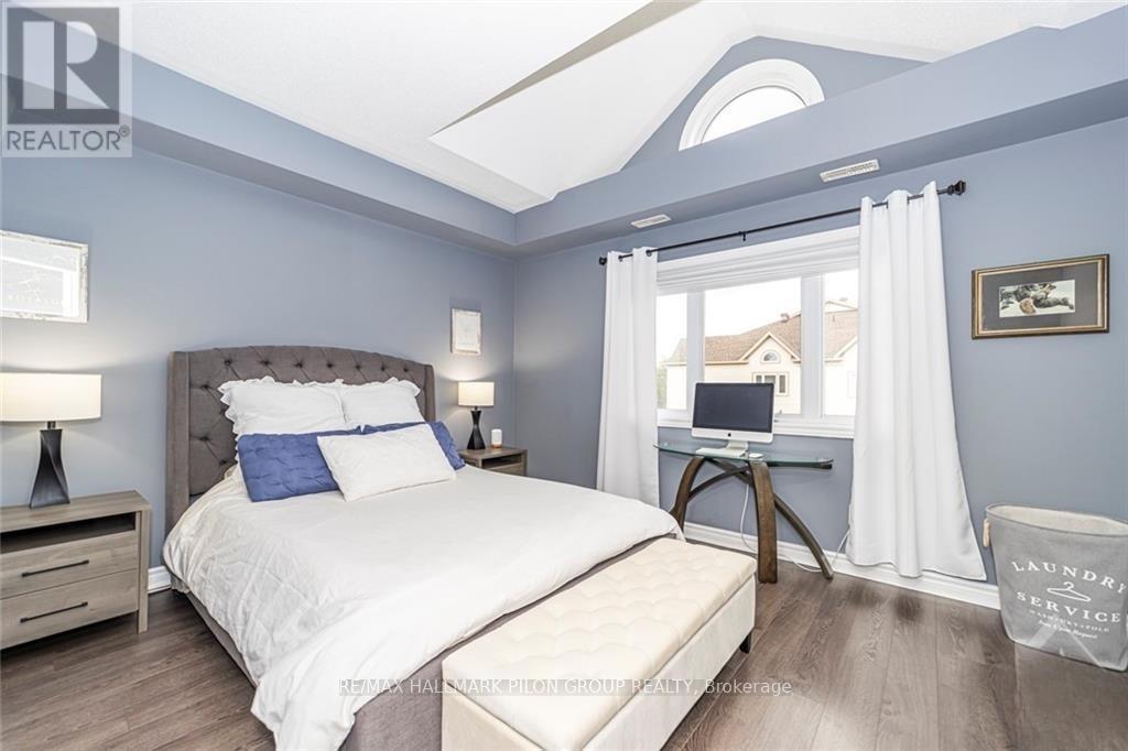 A bedroom with a bed, nightstands, and a window with white curtains.