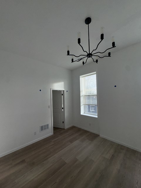 A room with a chandelier and a door.