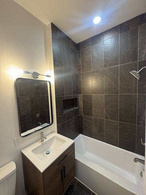 A bathroom with a white sink and a white bathtub.