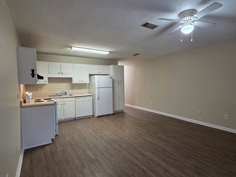 A kitchen with white cabinets and a white refrigerator.