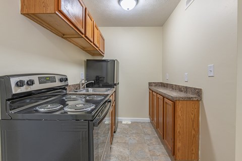 A kitchen with a black stove top oven and a black microwave.