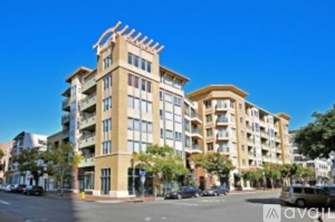 A tall apartment building with a balcony on the top floor.