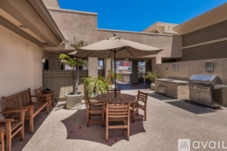 A patio with a table and chairs and an umbrella.