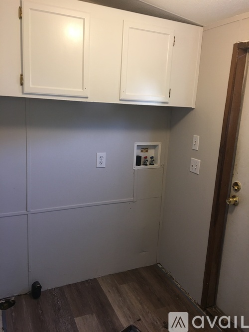 A kitchen with white cabinets and a wooden floor.