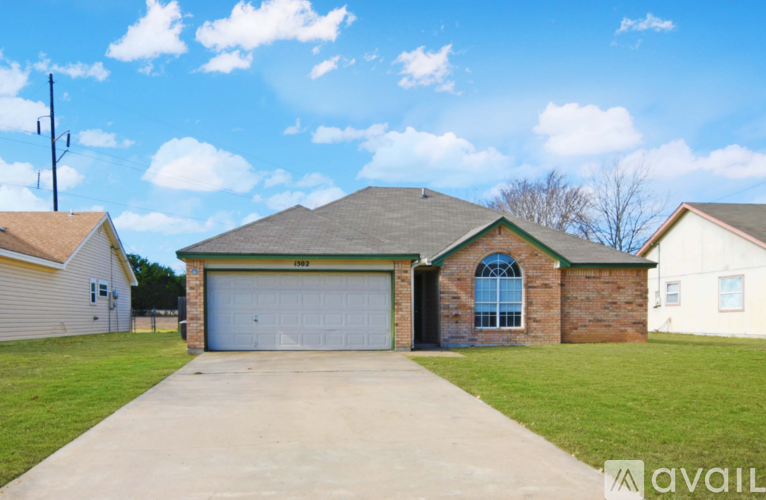 A house with a garage and a driveway in front of it.