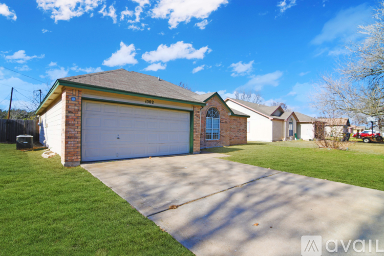 A house with a garage and a driveway in front of it.