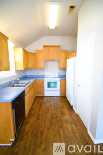 A kitchen with wooden cabinets and a white fridge.
