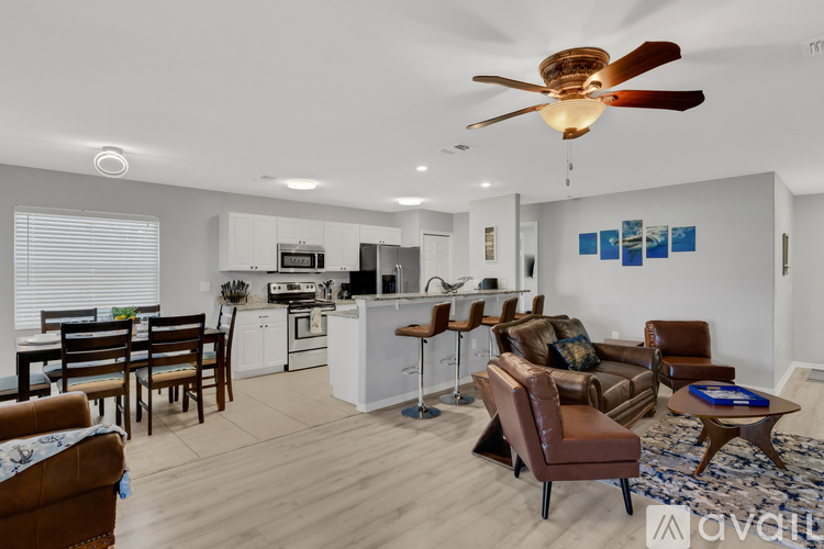 A modern living room with a kitchen in the background.
