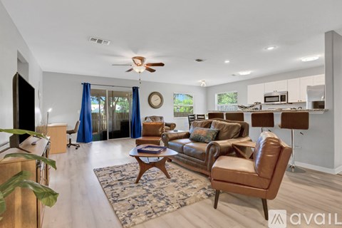 A living room with a brown leather couch and a rug.