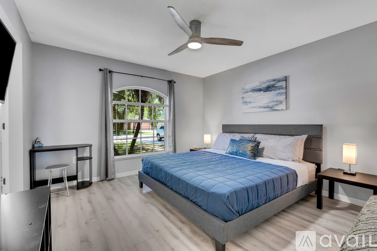 A bedroom with a large bed and a ceiling fan.