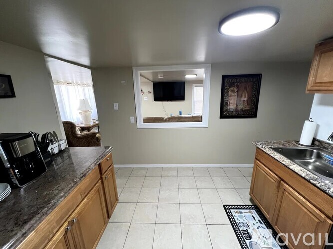 A kitchen with wooden cabinets and a granite countertop.