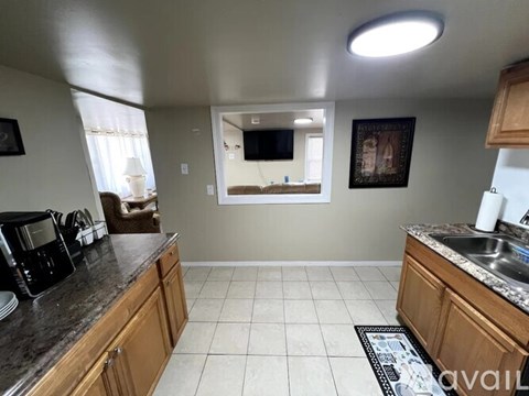 A kitchen with wooden cabinets and a granite countertop.