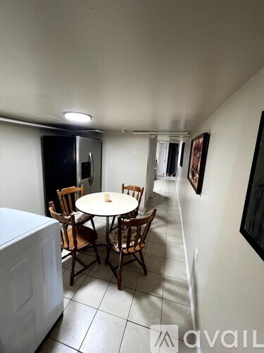 A dining room with a table and chairs.