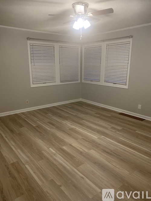 A room with wooden flooring and a ceiling fan.