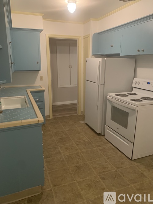 A kitchen with a white stove and blue cabinets.