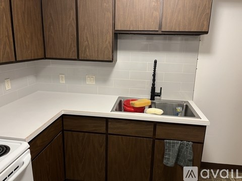 A kitchen with wooden cabinets and a white stove.