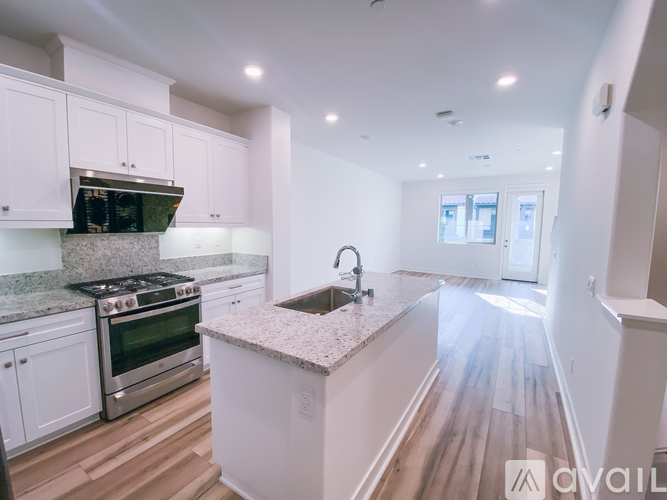 A kitchen with white cabinets and a granite countertop.