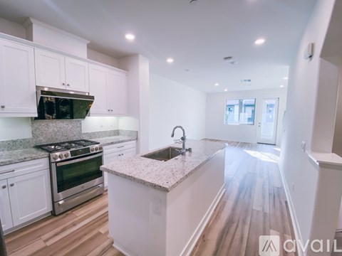A kitchen with white cabinets and a granite countertop.