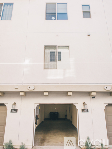 A white building with a garage door that has the number 2621 on it.