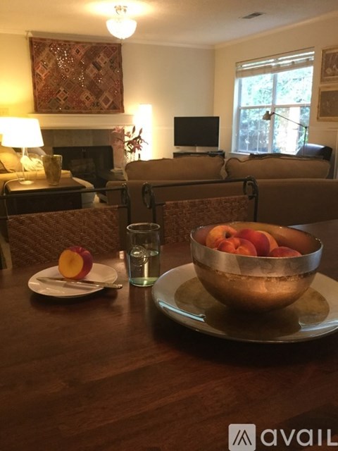 A table with a bowl of peaches and a glass of water is in the foreground.