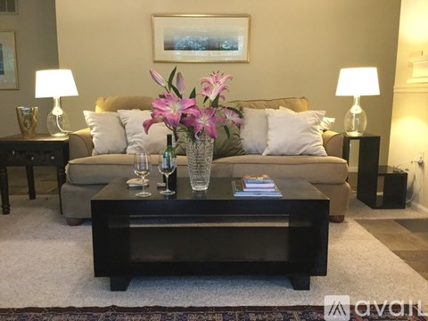 A living room with a couch, coffee table, and two lamps.