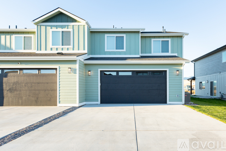 A two-story house with a garage door and a driveway.